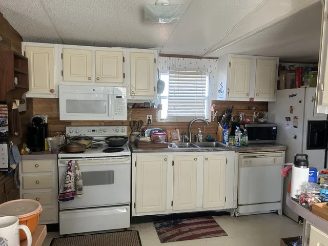 a kitchen with white cabinets and white appliances