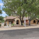 a view of house with yard and trees in the background