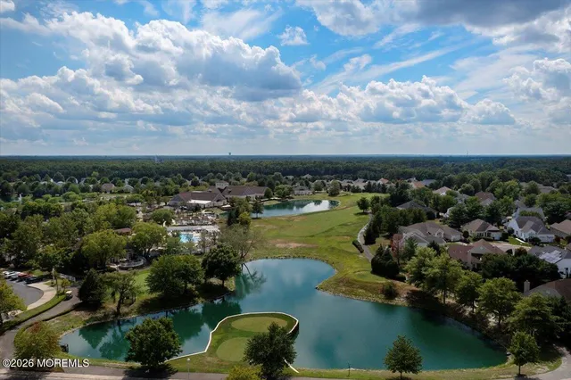 an aerial view of residential houses with outdoor space and lake view