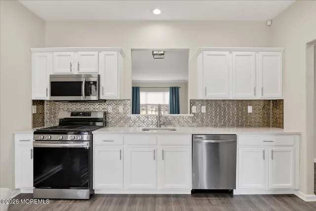 a kitchen with white cabinets and appliances