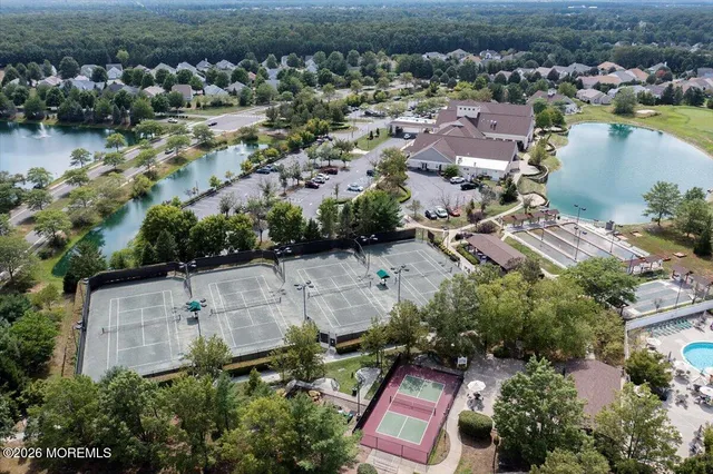 an aerial view of residential houses with outdoor space and lake view