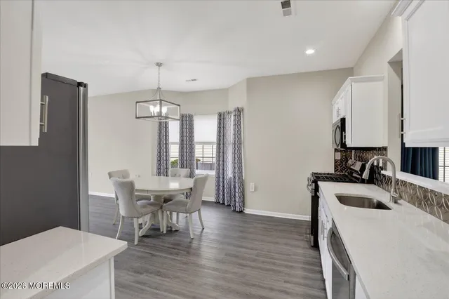 a kitchen that has a table chairs and wooden floor
