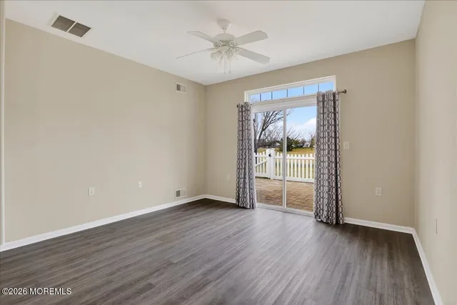 an empty room with wooden floor and door