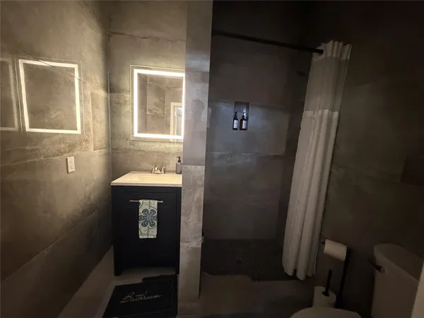 a bathroom with a sink a toilet and shower