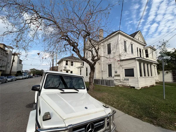 a view of a white house with a yard and tv