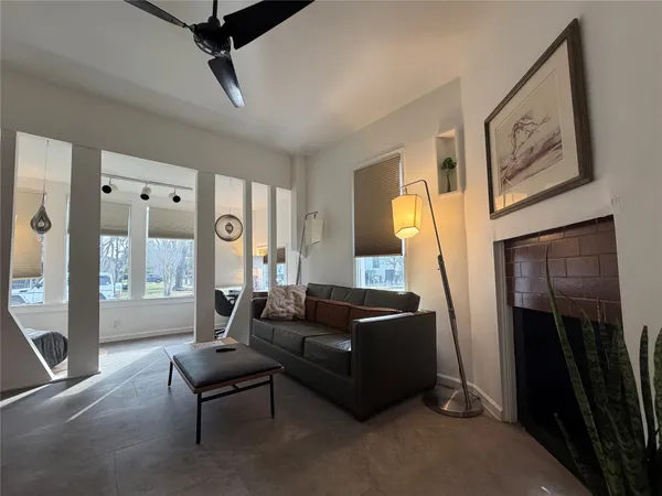 a living room with furniture a large window and a fireplace