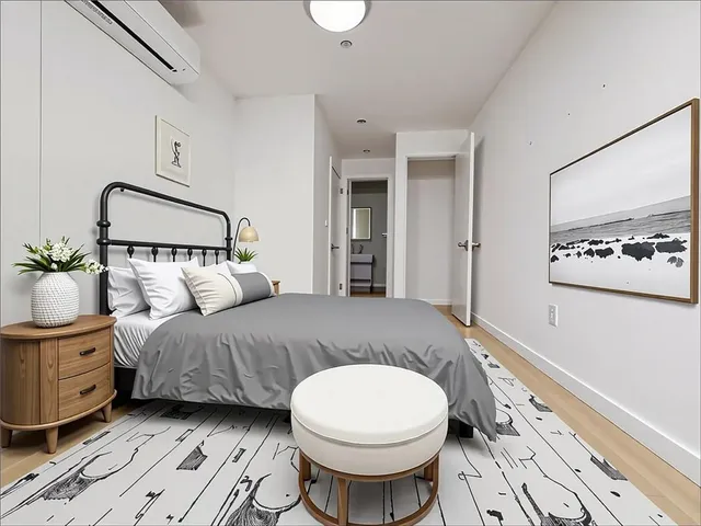 a spacious bedroom with a bed a mirror and lamp