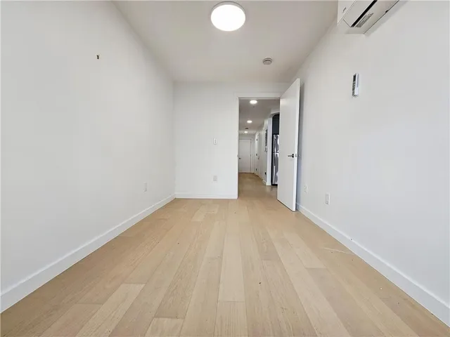 a view of a room with wooden floor and white walls