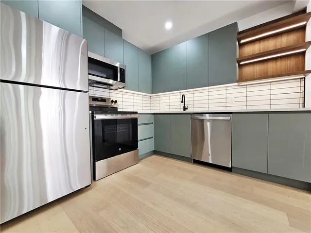 a kitchen with stainless steel appliances granite countertop a refrigerator and a sink