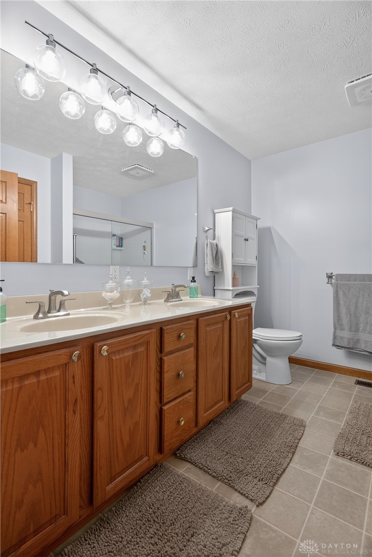5264 Frazier-Guy Road Sidney, OH 45365 - Photo 25 of 51 This spacious bathroom offers dual vanities and tiled flooring, enhancing daily routines.