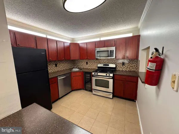 a kitchen with stainless steel appliances granite countertop a refrigerator and a stove