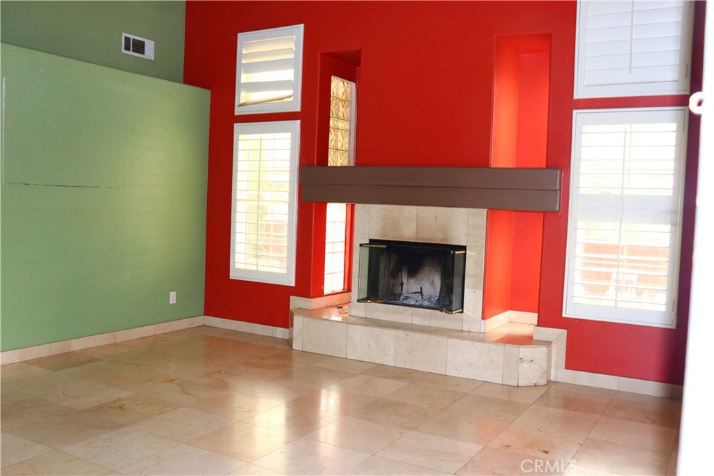 5642 Lighthouse Lane Palmdale, CA 93552 - Photo 4 of 24 a view of an empty room with a fireplace and a window