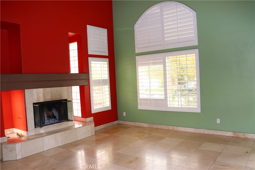 5642 Lighthouse Lane Palmdale, CA 93552 - Photo 5 of 24 a view of an empty room with a fireplace and a window