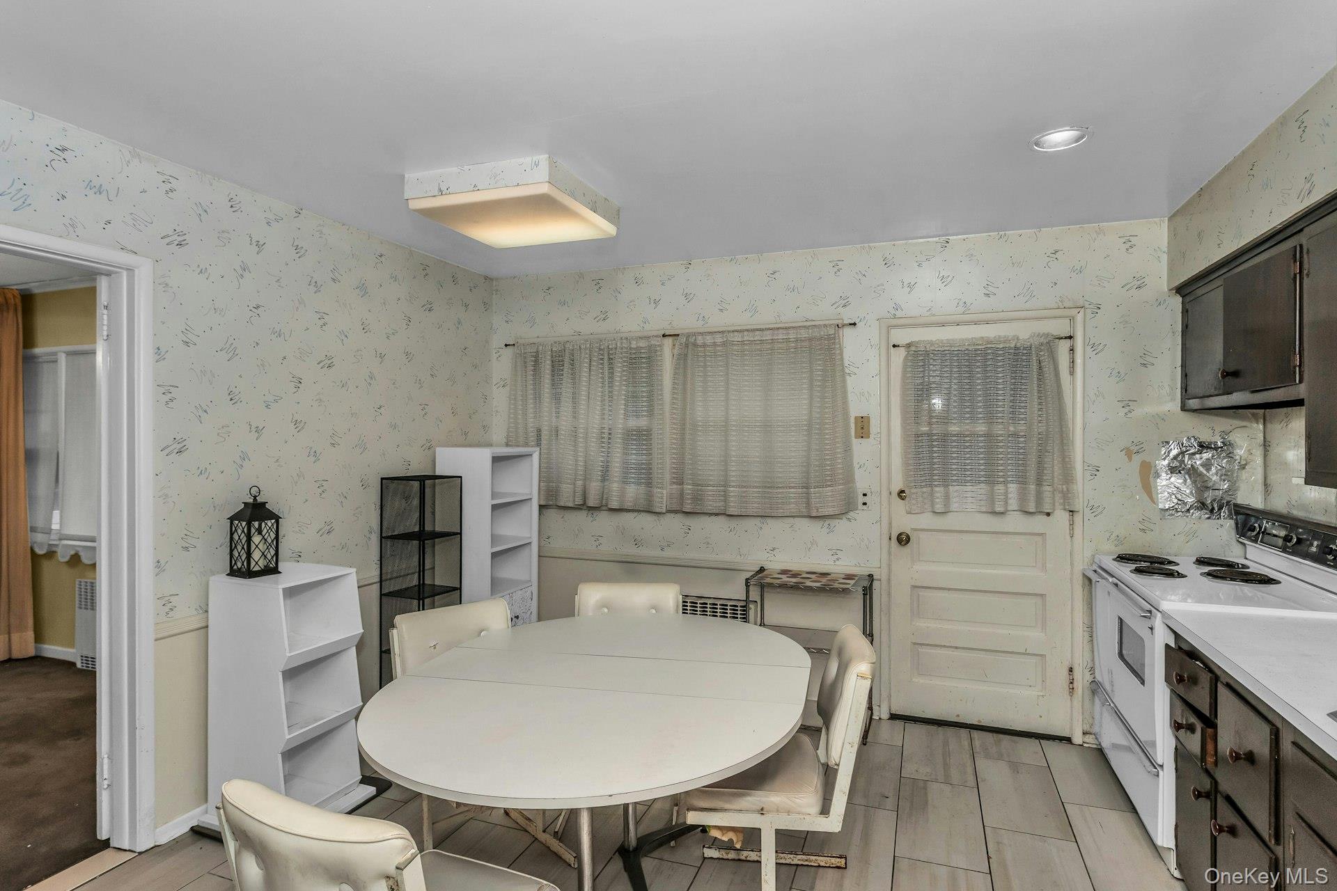 477 Demott Avenue Baldwin, NY 11510 - Photo 11 of 27 a kitchen with stainless steel appliances a sink a stove a table and chairs