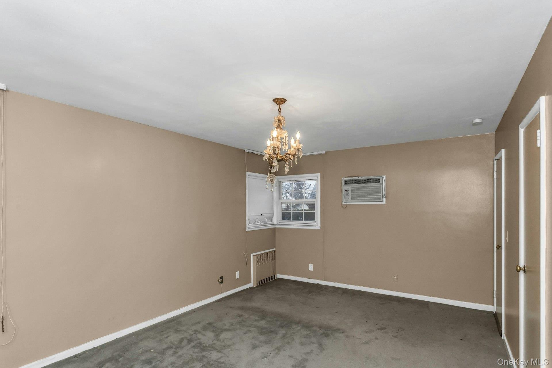 477 Demott Avenue Baldwin, NY 11510 - Photo 17 of 27 an empty room with windows and chandelier