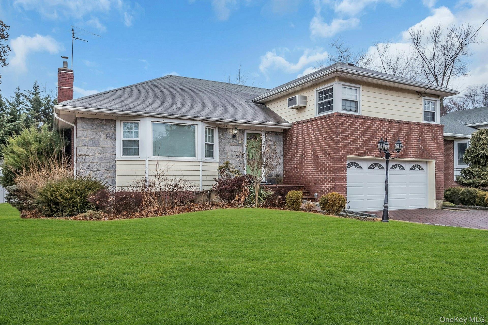 477 Demott Avenue Baldwin, NY 11510 - Photo 2 of 27 a front view of a house with a garden and yard