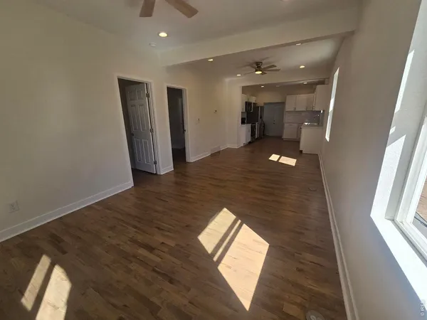 a view of a hallway with wooden floor and glass door