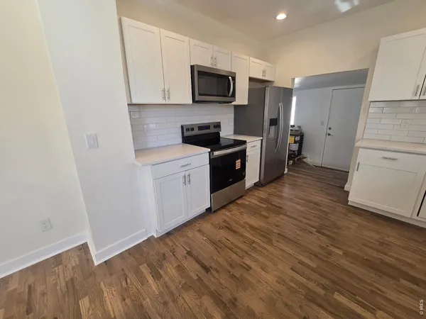 a kitchen with stainless steel appliances granite countertop a stove a sink and a refrigerator