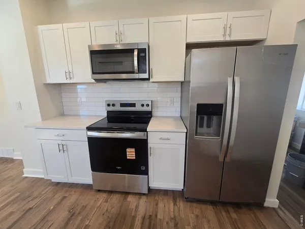 a kitchen with stainless steel appliances a refrigerator microwave and sink