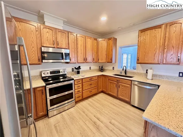 a kitchen with stainless steel appliances a stove sink microwave and cabinets