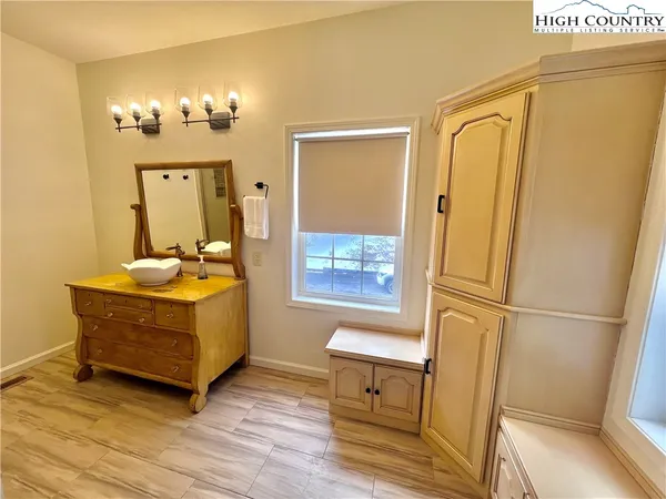a view of a hallway with wooden floor and furniture