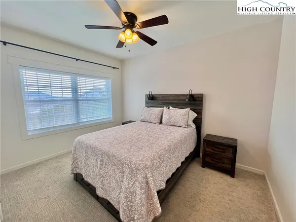 a bedroom with a bed and a ceiling fan