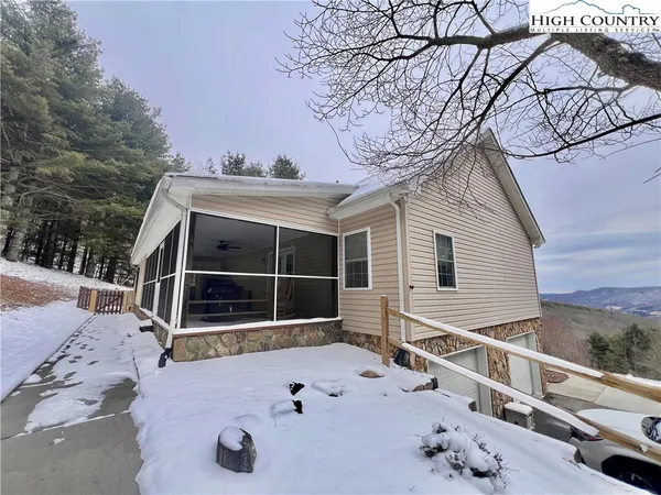 a view of a house with a wooden fence and a trees