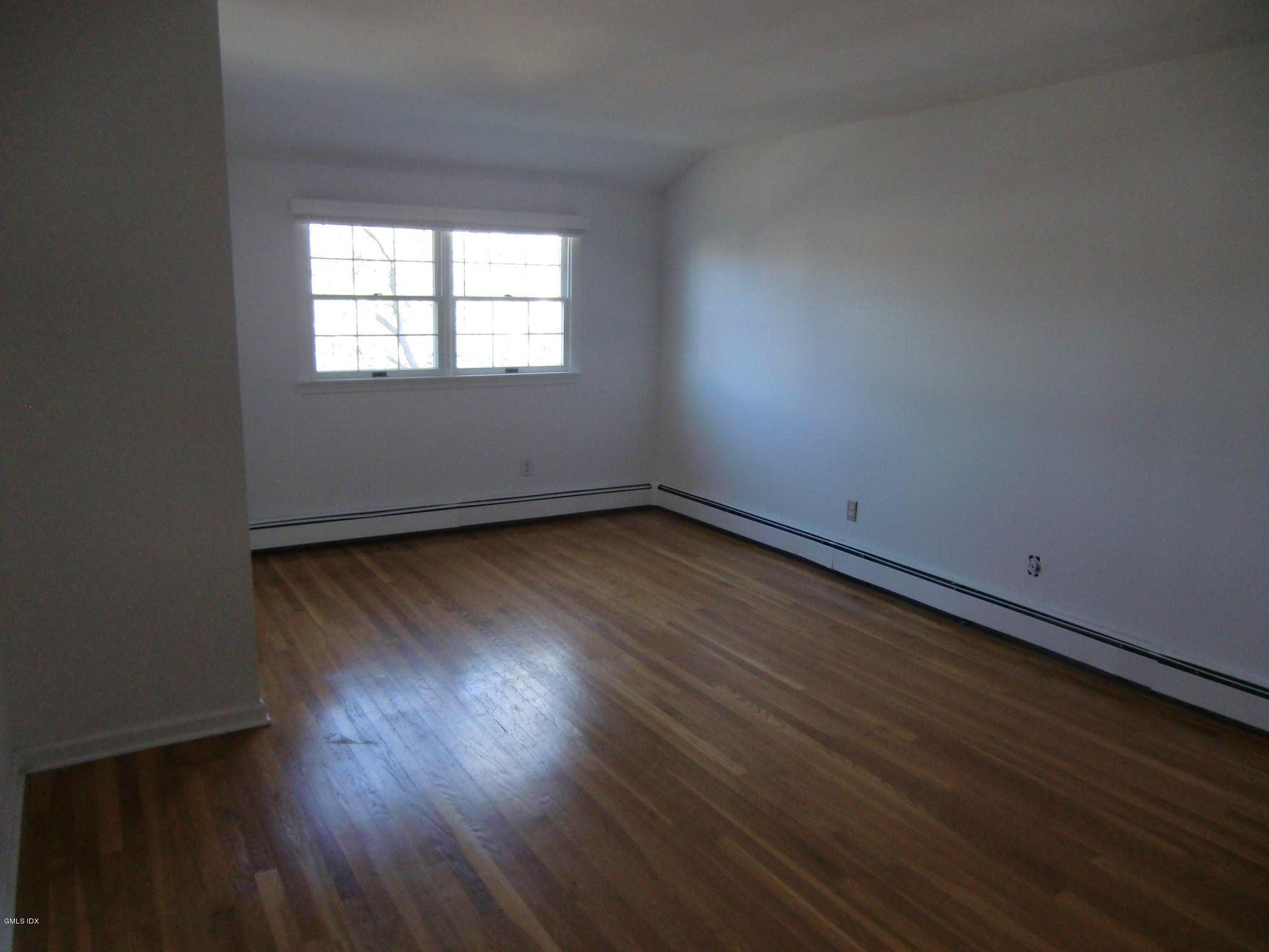 42 Harold Street Cos Cob, CT 06807 - Photo 6 of 10 an empty room with wooden floor and windows
