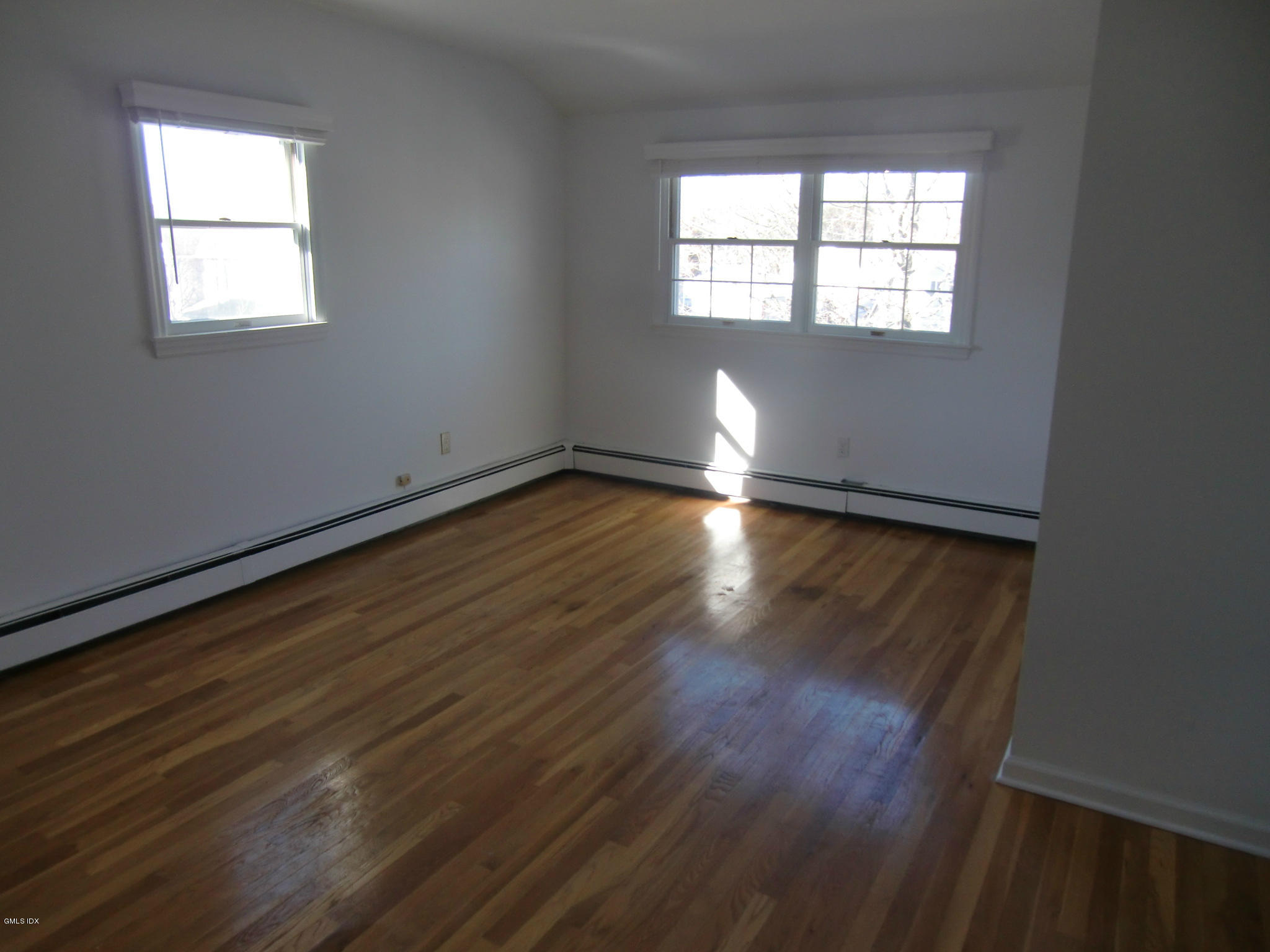42 Harold Street Cos Cob, CT 06807 - Photo 7 of 10 an empty room with wooden floor and windows