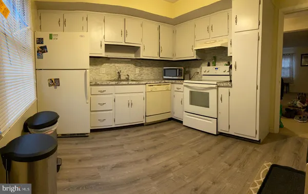 a kitchen with cabinets appliances and wooden floor