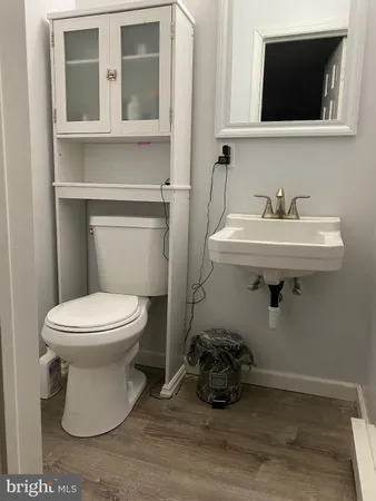 a bathroom with a toilet a sink and mirror