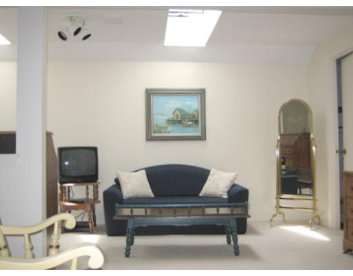 103 D Ridgefield Circle, Unit D Clinton, MA 01510 - Photo 8 of 12 a living room with furniture and a painting on the wall