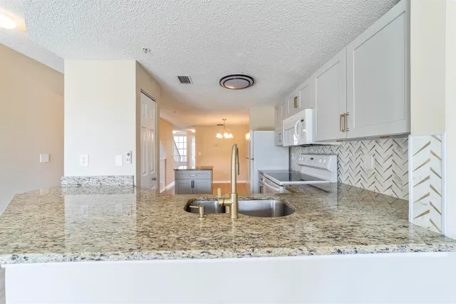 a kitchen with white cabinets and white appliances