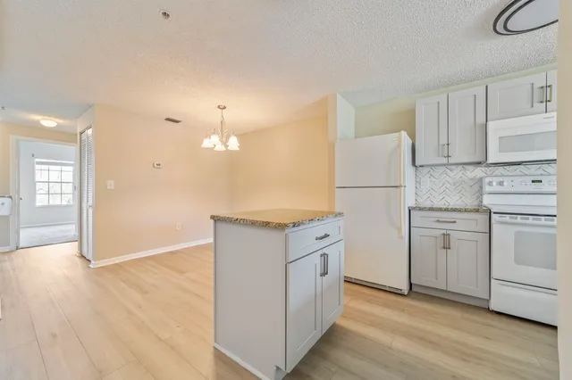 a view of a kitchen with a dishwasher cabinets and wooden floor