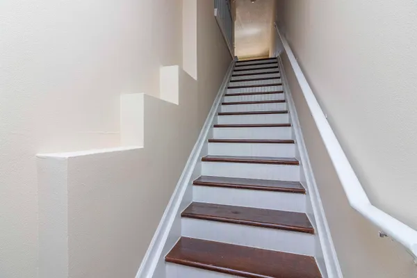 a view of a hallway with wooden floor and entryway