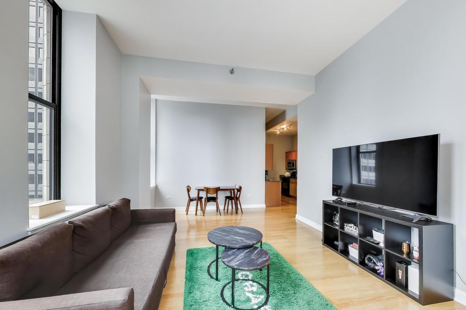 8 West Monroe Street, Unit 704 Chicago, IL 60603 - Photo 11 of 35 a living room with furniture and a flat screen tv