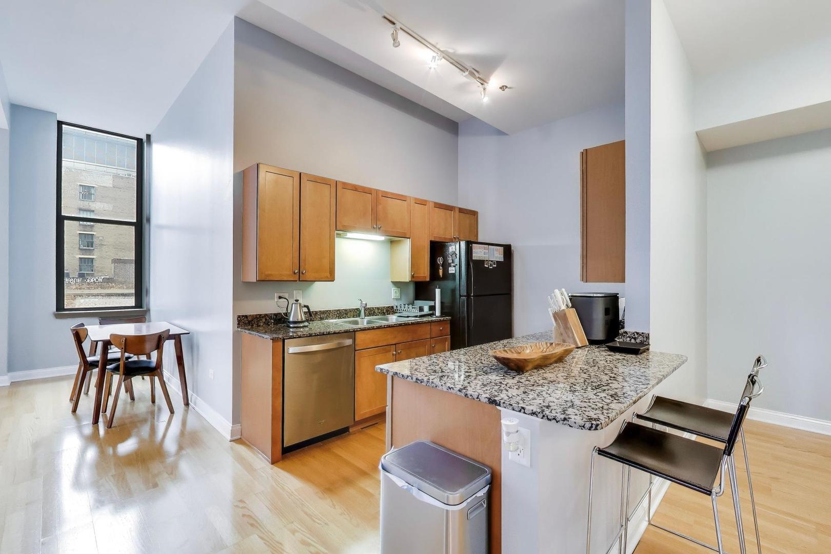 8 West Monroe Street, Unit 704 Chicago, IL 60603 - Photo 12 of 35 a kitchen with stainless steel appliances granite countertop sink stove top oven and cabinets