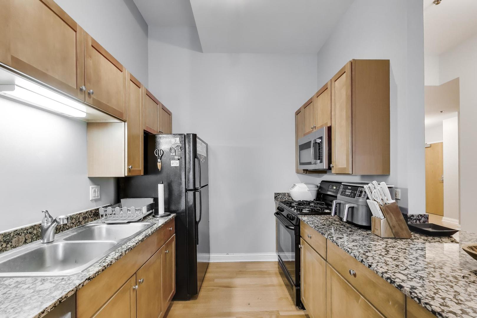 8 West Monroe Street, Unit 704 Chicago, IL 60603 - Photo 13 of 35 a kitchen with stainless steel appliances granite countertop a sink stove and refrigerator