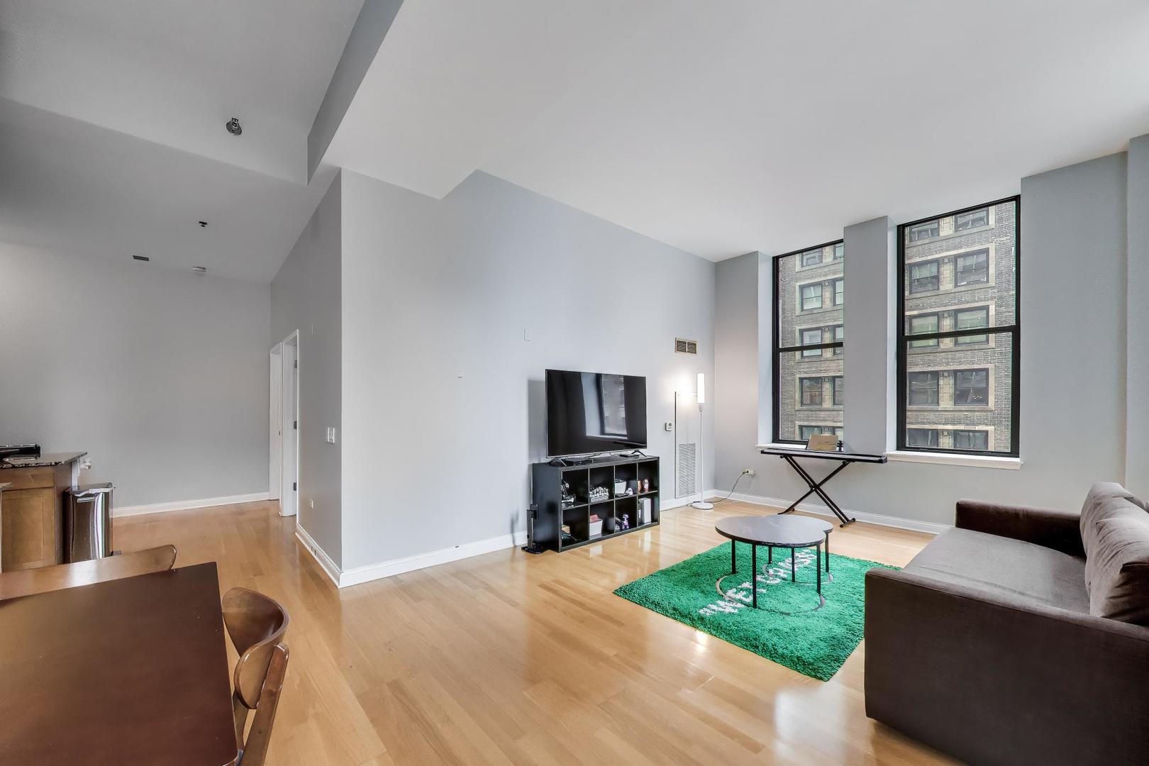 8 West Monroe Street, Unit 704 Chicago, IL 60603 - Photo 9 of 35 a living room with furniture and a flat screen tv