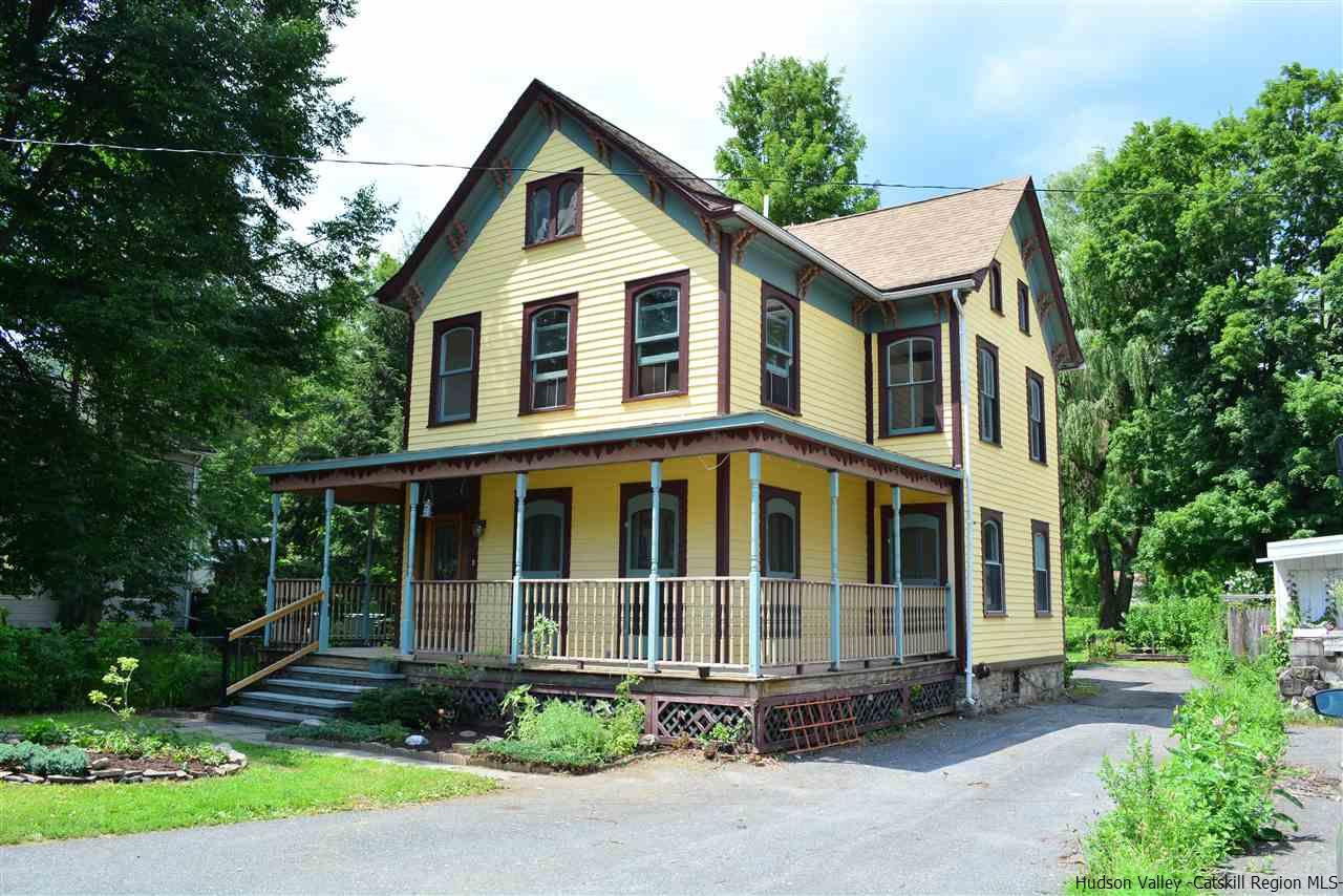 a view of a white house with large windows and plants