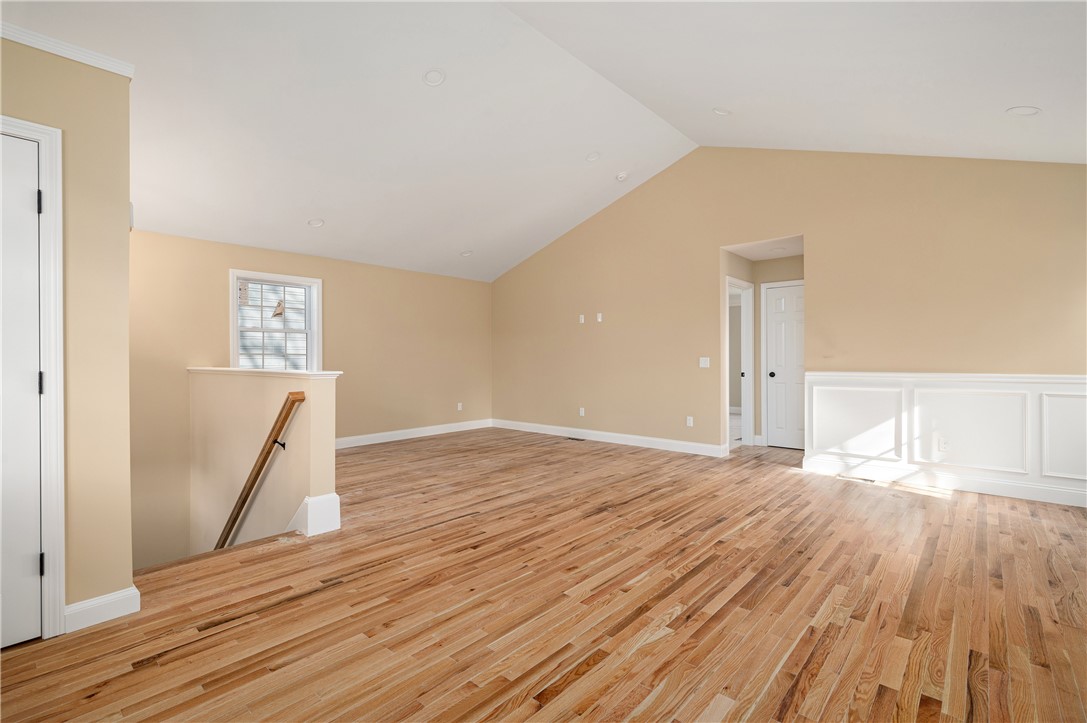23 Henry Street Woonsocket, RI 02895 - Photo 3 of 33 Enter into a spacious open concept living area. The vaulted ceiling adds dimension to the room. Note the detailed wainscoting.