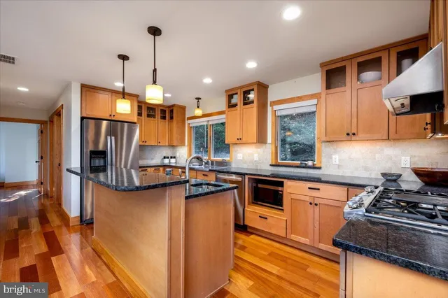 a kitchen with stainless steel appliances granite countertop a sink and a window