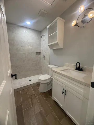 a bathroom with a sink a toilet and shower