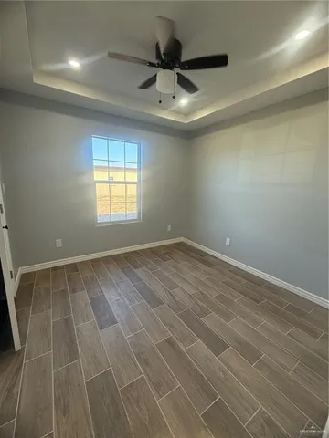 en empty room with windows and ceiling fan