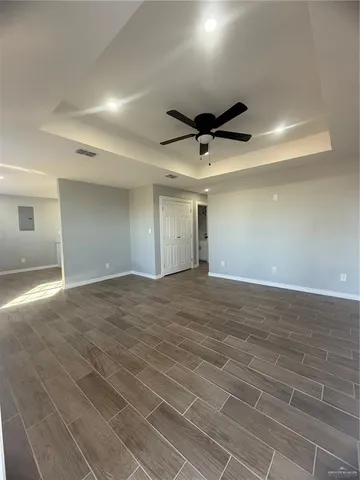 a view of an empty room and chandelier fan
