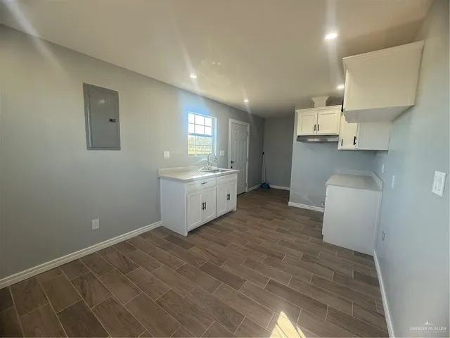 a kitchen with a sink cabinets and wooden floor
