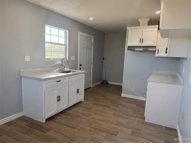a kitchen with a sink a window and cabinets