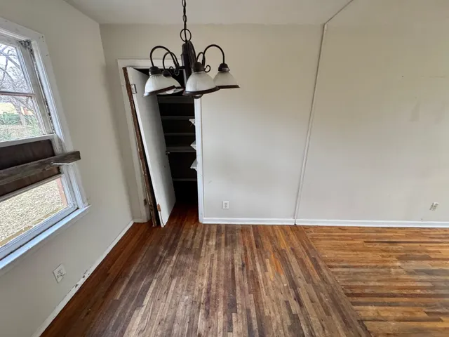 a view of empty room with wooden floor