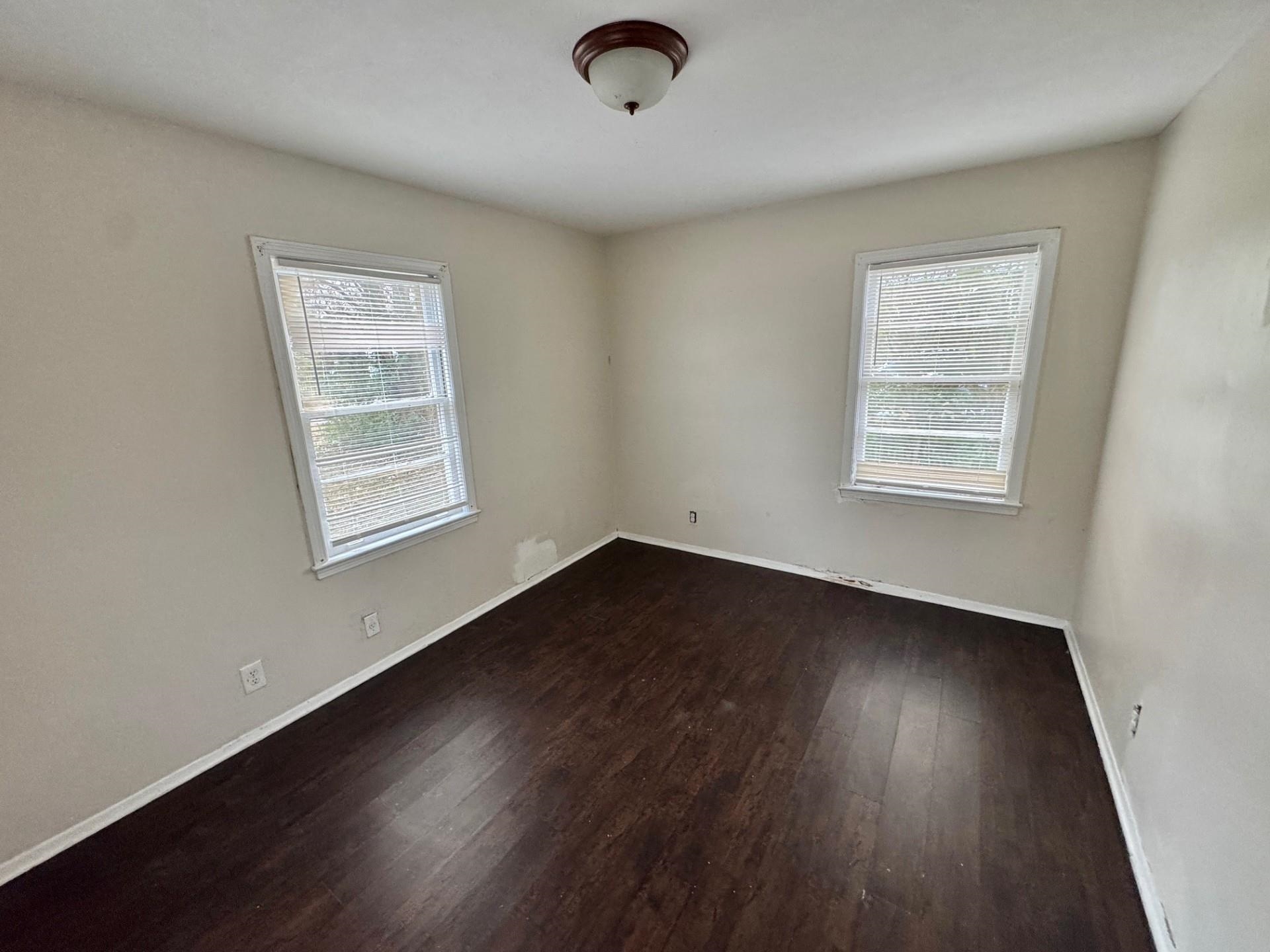 4967 Newton Road Memphis, TN 38109 - Photo 10 of 12 an empty room with wooden floor and windows