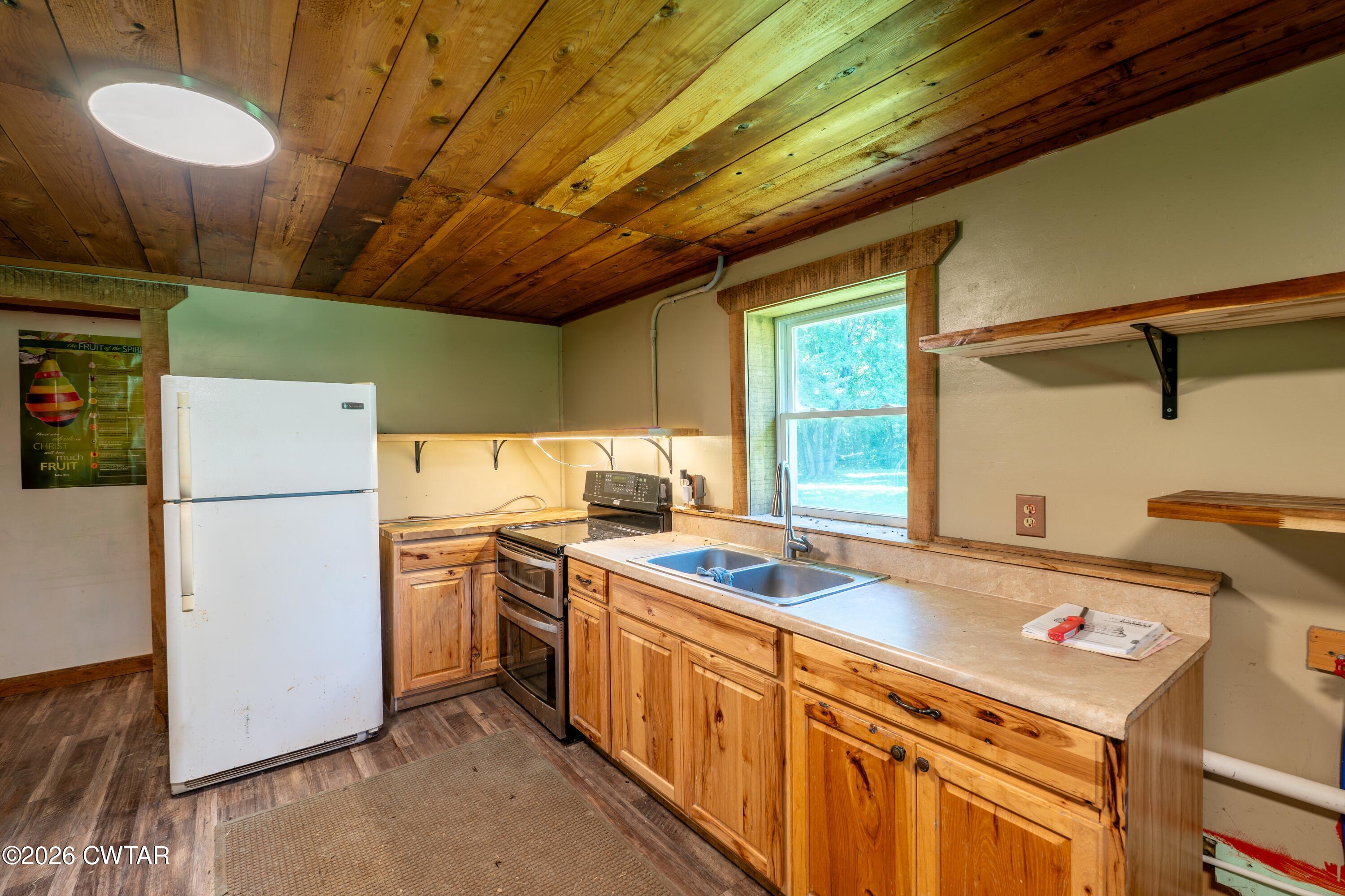 3454 Treece Road Hornbeak, TN 38232 - Photo 14 of 25 a kitchen that has a sink a stove and a refrigerator